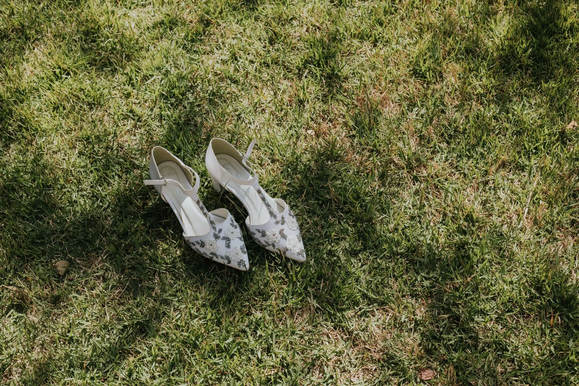 Talon bloc en satin champagne et stiletto équipé d'un protège-talon transparent : deux approches pour tenir sur gazon lors d'une cérémonie en plein air